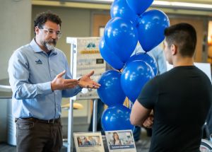 AHFC staff talking with a prospective applicant at a career fair.
