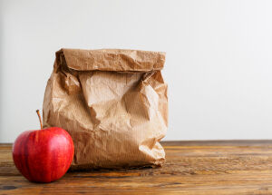 Photo of a brownbag lunch with red apple. 