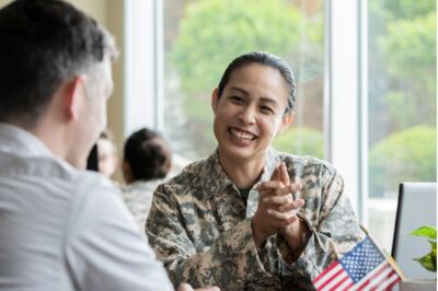 Female Military Recruiter Smiling While Discussing Options With Another Soldier